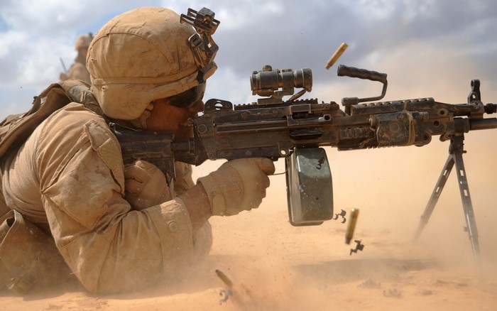 Soldier firing a machine gun in the desert