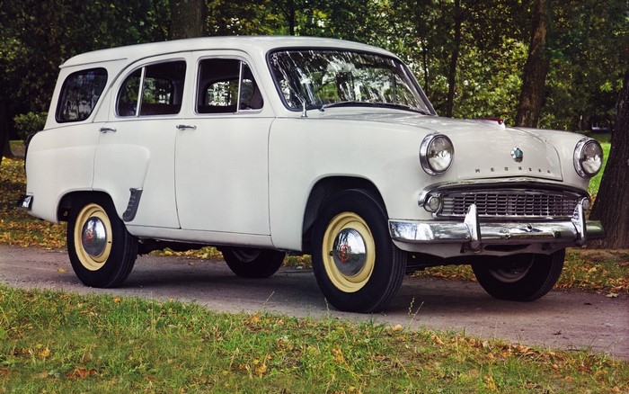 White Moskvich car parked on a dirt road