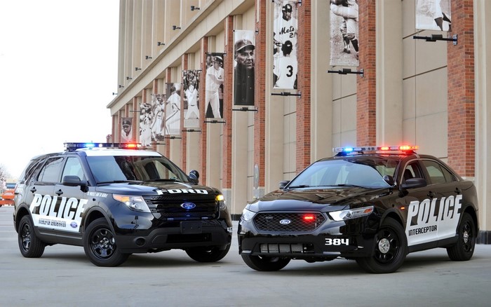 Two Ford Police Interceptor vehicles parked outside a building