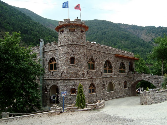 Stone castle with flags and arched bridge