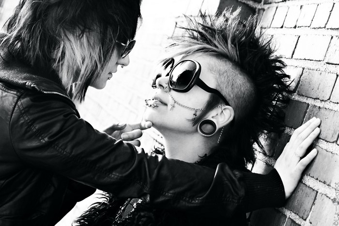 Two people with piercings and sunglasses