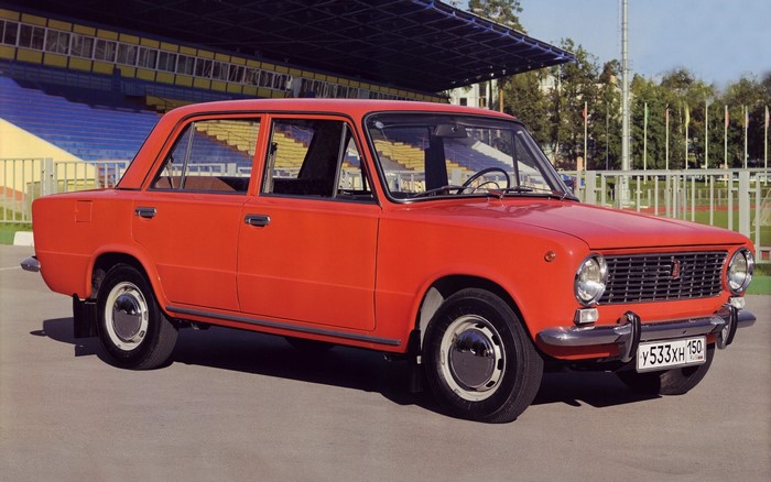 Red Lada car parked near stadium bleachers