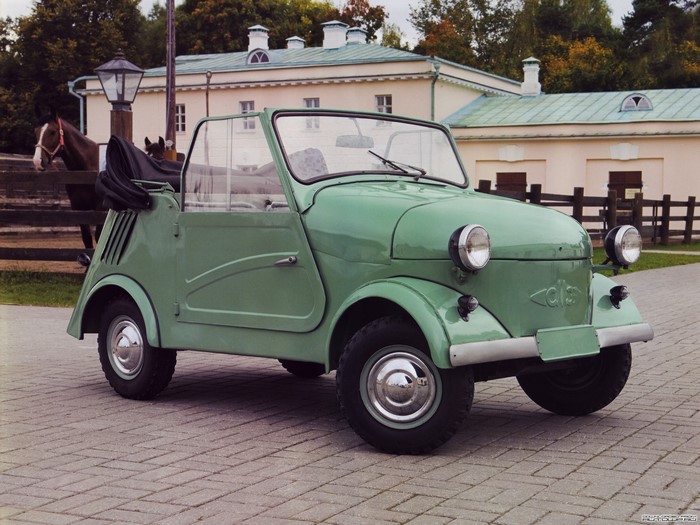 Small green convertible car in front of a building
