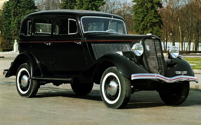 Black 1930s sedan parked on asphalt road