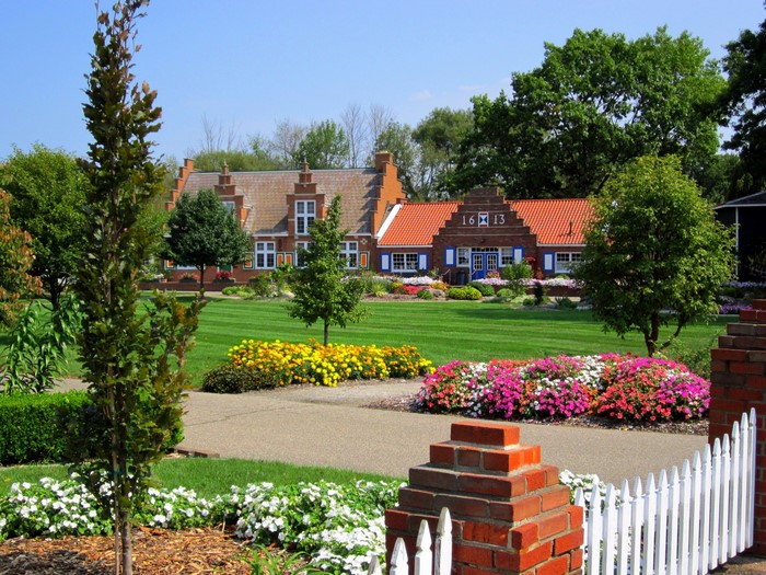 Dutch-style buildings in a park with flowers