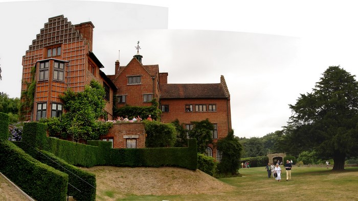 Brick house with gardens and people walking