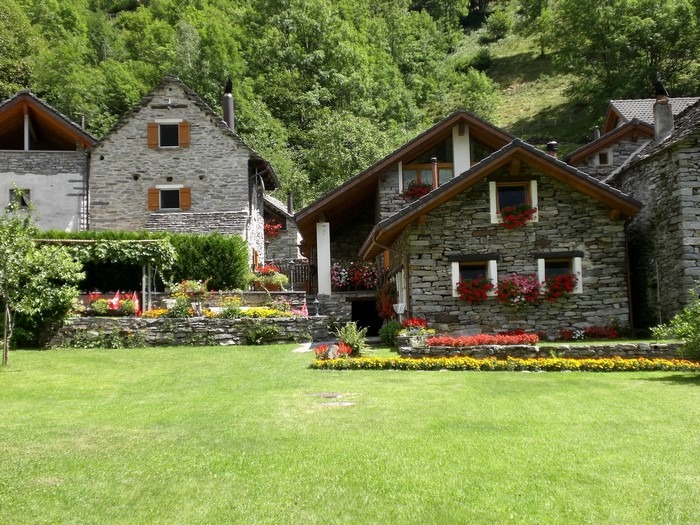 Stone houses with flower gardens in a green mountain village