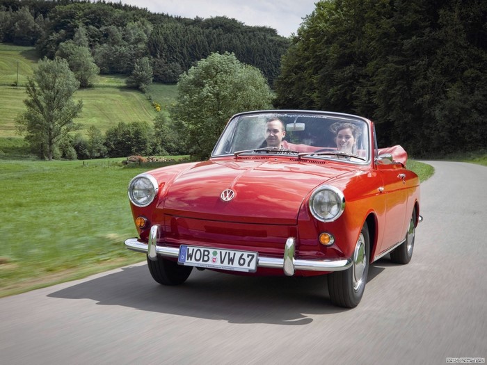 Red Volkswagen Convertible driving on a country road