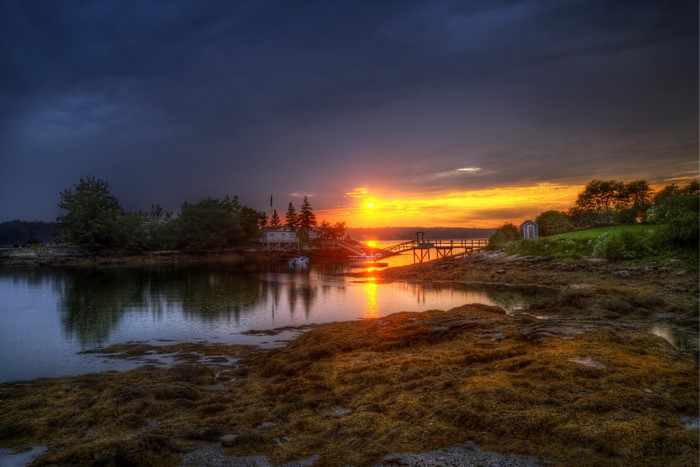 Sunset over a coastal village with a dock