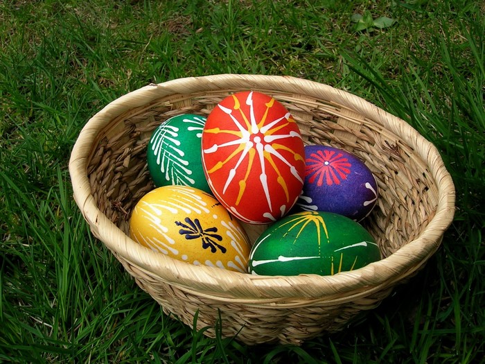 Decorated Easter eggs in a basket on grass