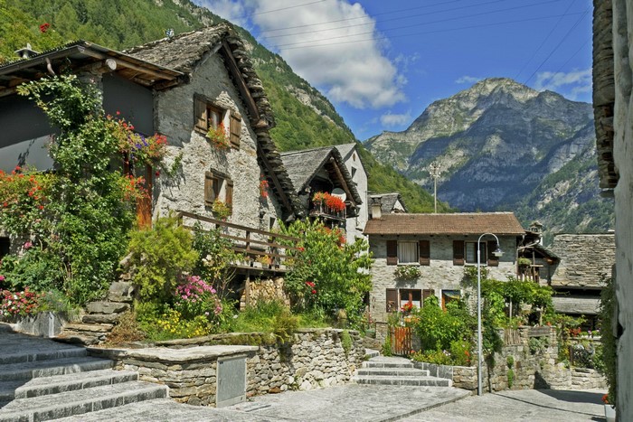 Stone houses in a Swiss mountain village with flowers