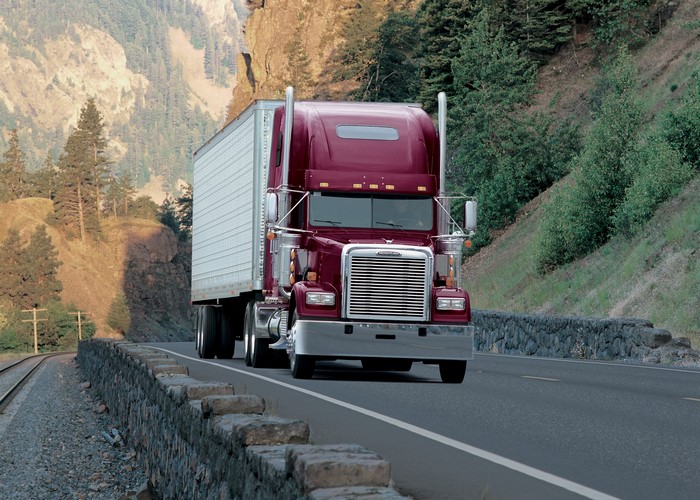 Maroon Freightliner Semi-Truck with Trailer on Road