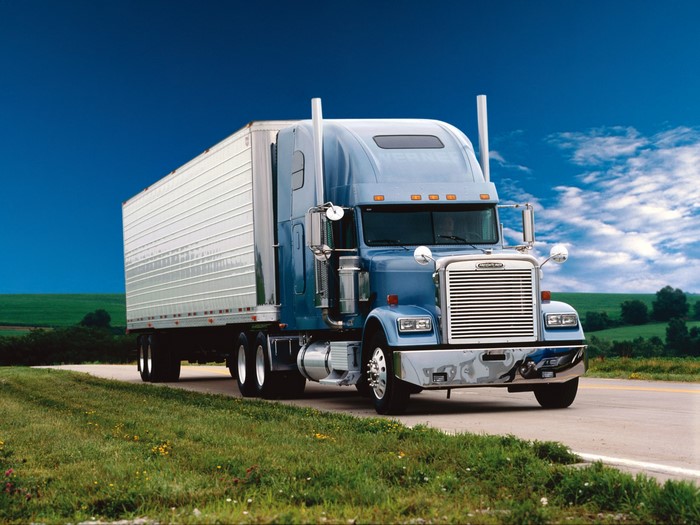 Blue Freightliner Semi-Truck with Trailer on Road