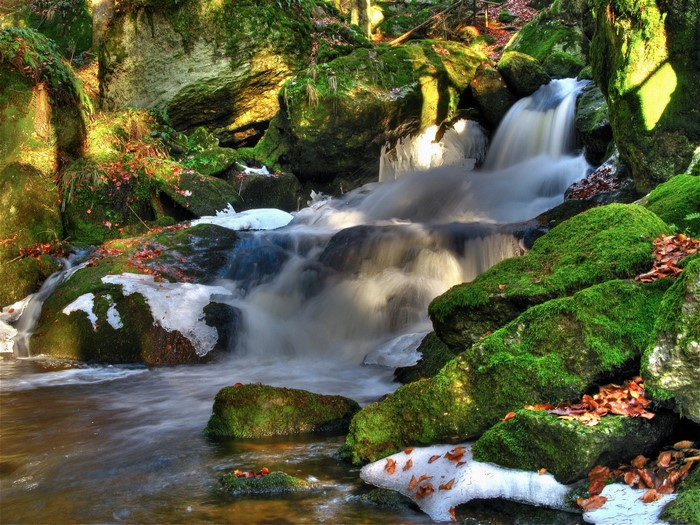 Mossy rocks and ice around a small waterfall