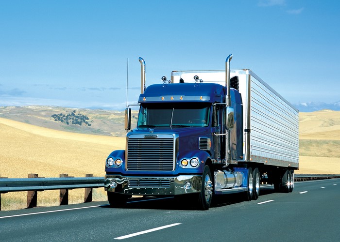 Blue Freightliner Semi-Truck Driving on Highway