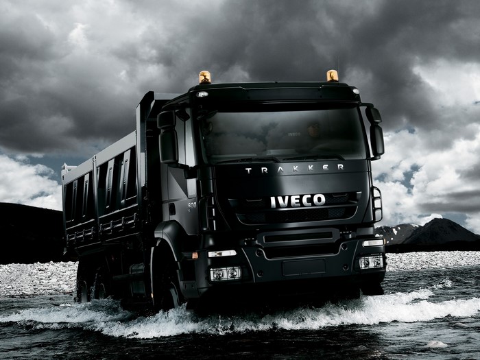 Black Iveco Trakker dump truck driving through water