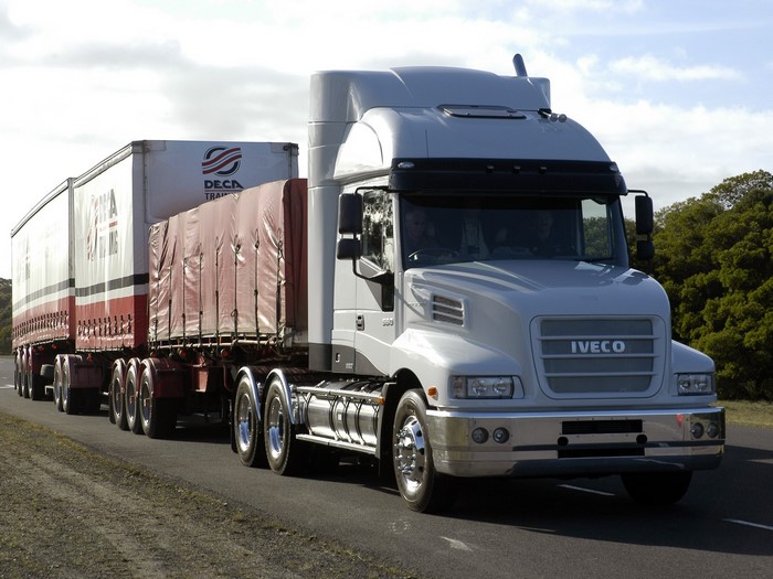 IVECO truck pulling two trailers on a road