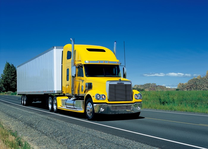 Yellow Freightliner Semi-Truck with Trailer on Road