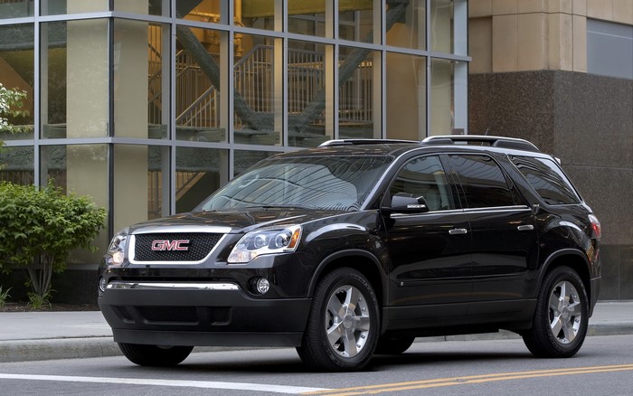 2009 GMC Acadia parked in front of a modern building