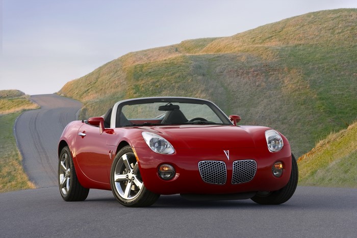 Red 2009 Pontiac Solstice Convertible on a Winding Road