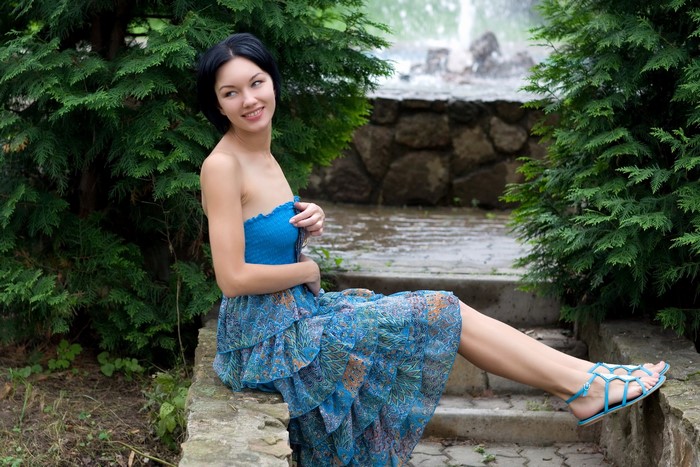 Woman in blue dress sitting on stone steps