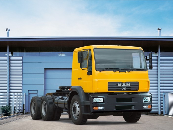 Yellow MAN SE Truck in Front of Building