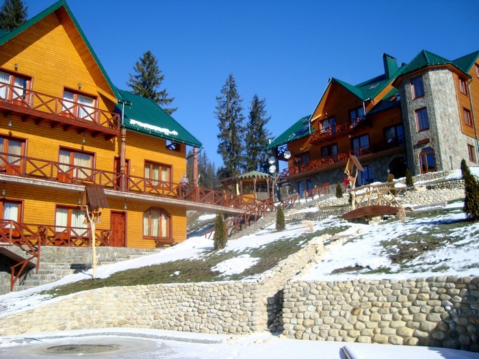 Wooden and stone resort buildings on a snowy hillside