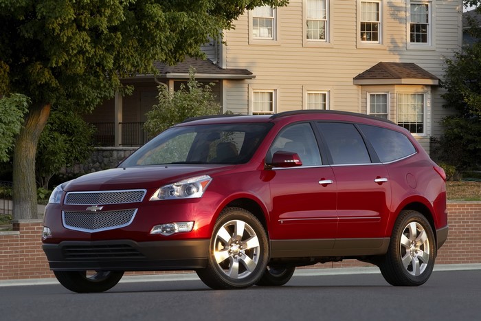 Red Chevrolet Traverse SUV parked outside a house