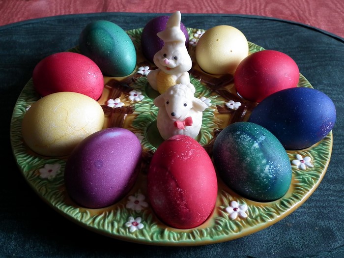 Easter eggs on a decorative plate with bunny and sheep figurines