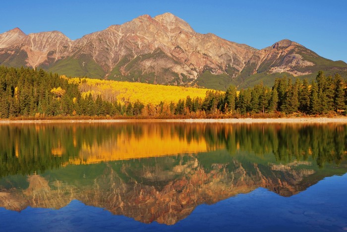 Mountains reflected in a lake with autumn trees