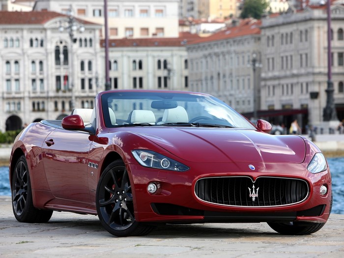 Red Maserati GranTurismo Convertible parked by water
