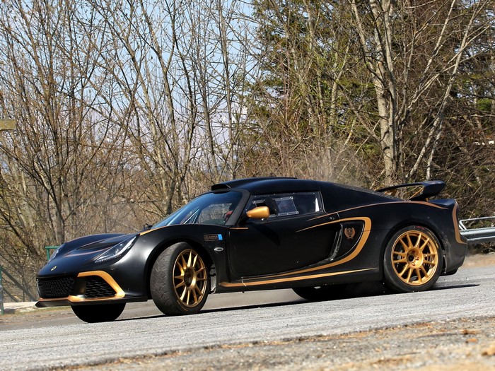 Black Lotus rally car with gold accents on a dirt road