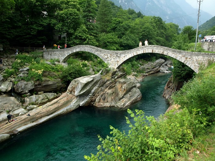 Stone bridge over a turquoise river in a forest