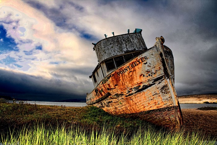 Old shipwrecked boat named Point Reyes on shore