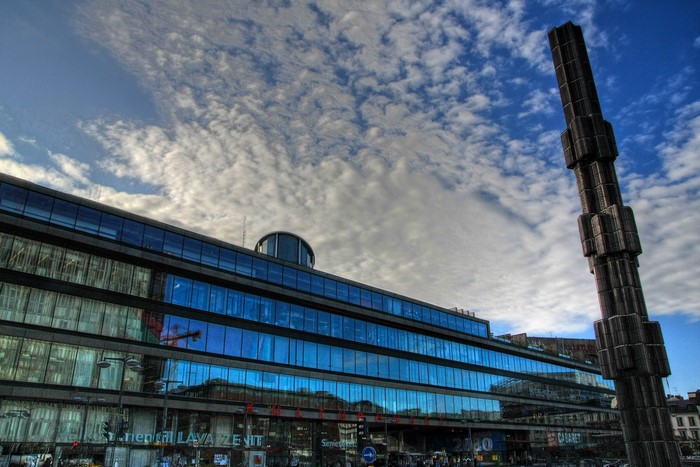 Modern building with blue windows and a tall sculpture