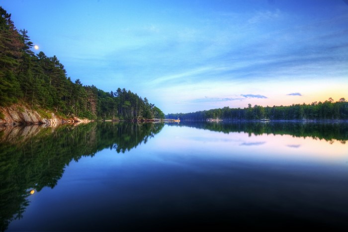 Moonlit lake with pine forest and reflection