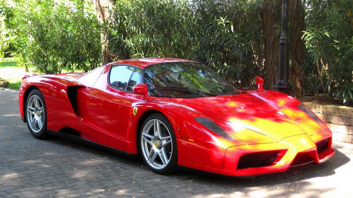Red Ferrari Enzo parked on a cobblestone path