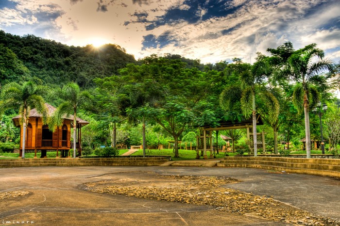 Wooden hut and gazebos in a tropical park with mountains