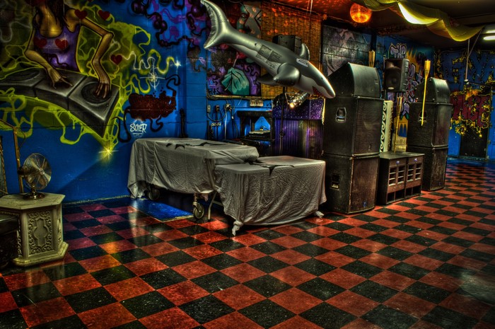 Graffiti-covered club interior with DJ mural and inflatable shark
