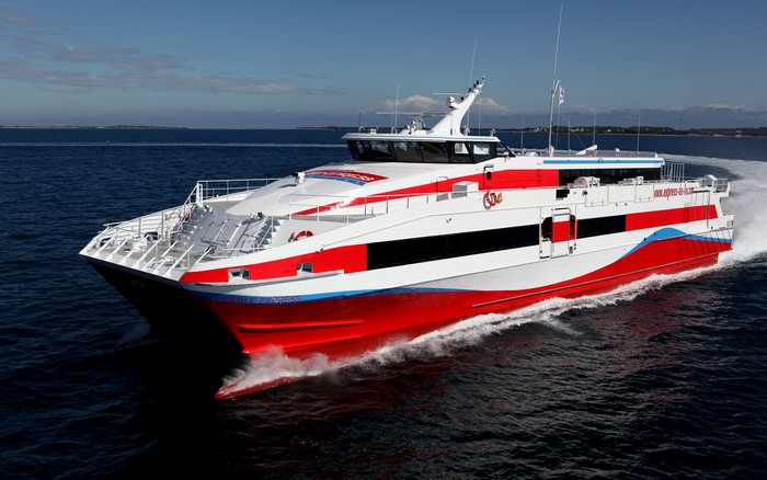Red and white express ferry sailing on the ocean