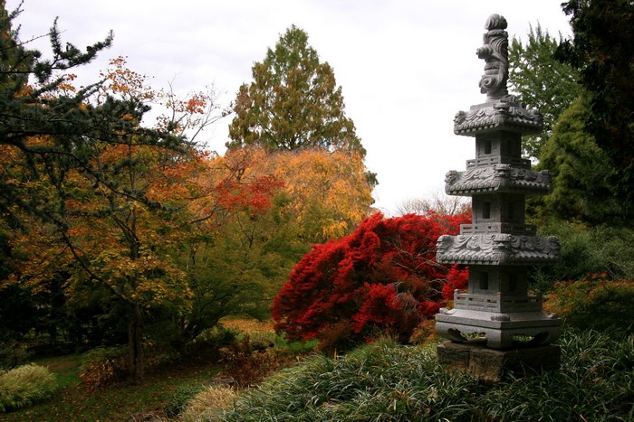 Stone pagoda in a garden with autumn foliage