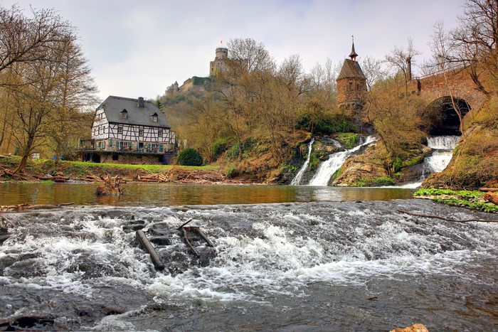 Waterfalls near a historic building and castle