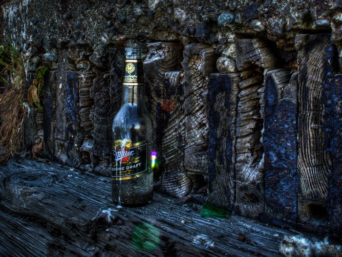 Miller Genuine Draft beer bottle on weathered wood