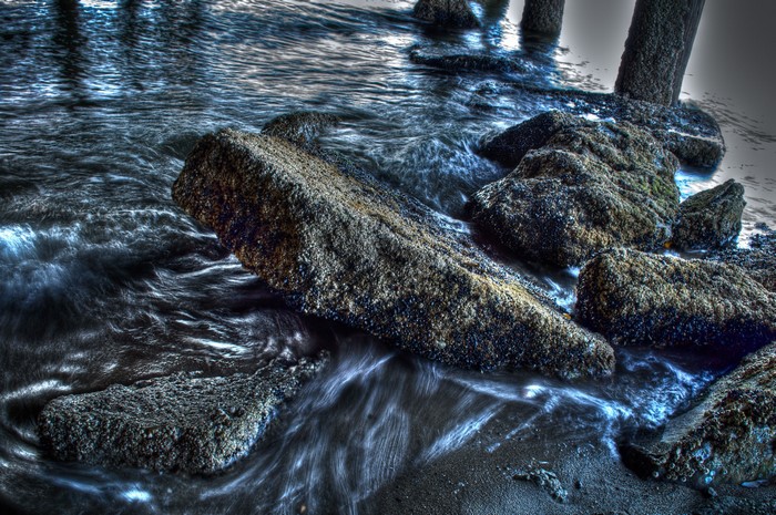 Rocks in the water near pillars