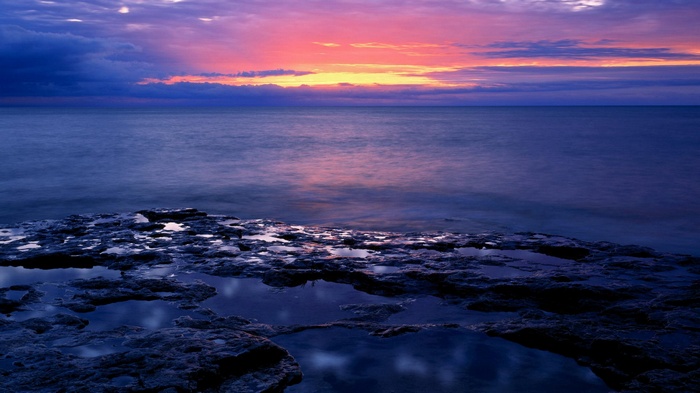 Ocean sunset with rocky shore and tide pools