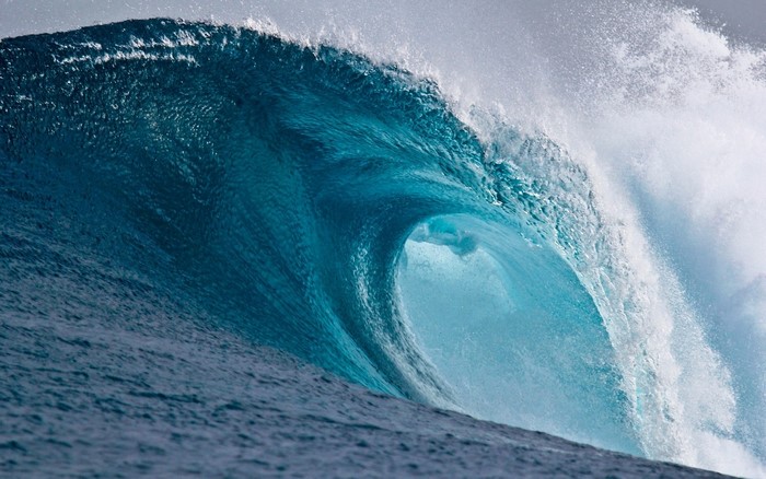 A powerful ocean wave barrels and breaks
