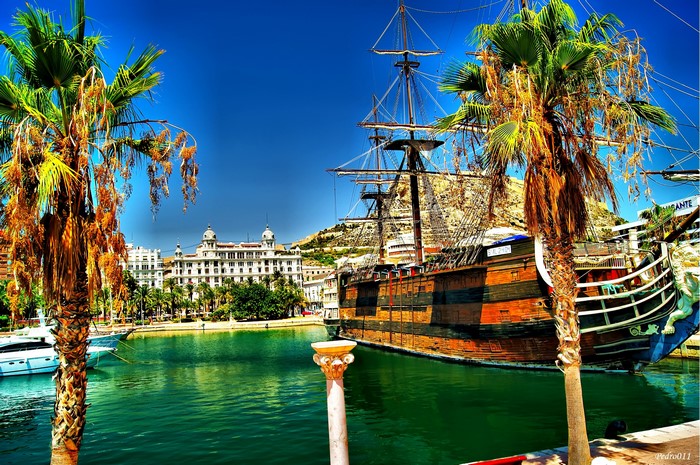 Replica Holy Trinity ship in a harbor with palm trees