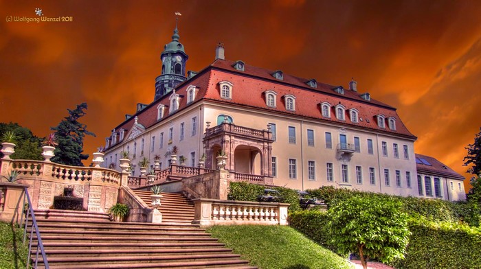 Castle with grand staircase and dramatic sky