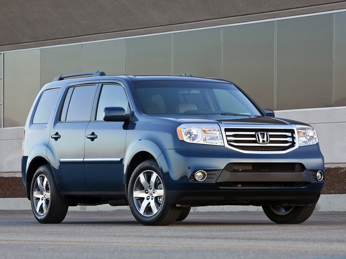 Blue Honda Pilot SUV parked in front of a modern building