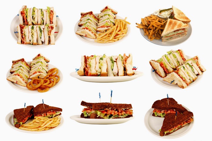 Various club sandwiches with fries and onion rings